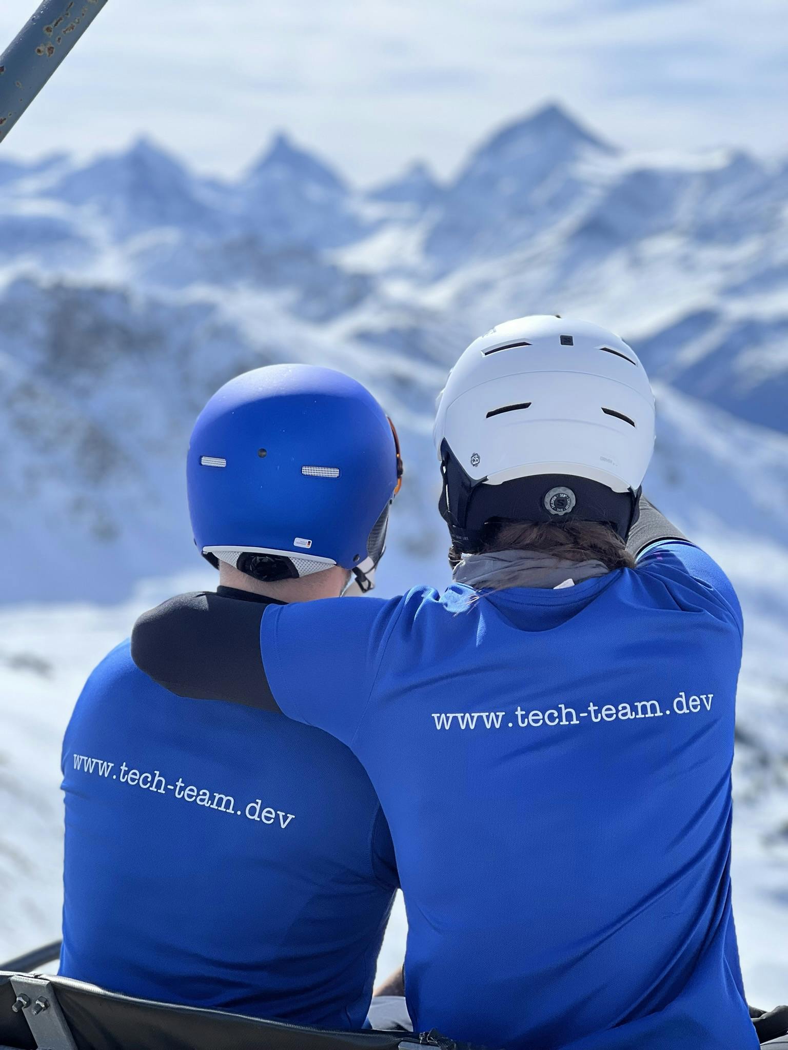 Zwei Skifahrer tragen ein T-Shirt mit der Aufschrift "www.tech-team.dev"